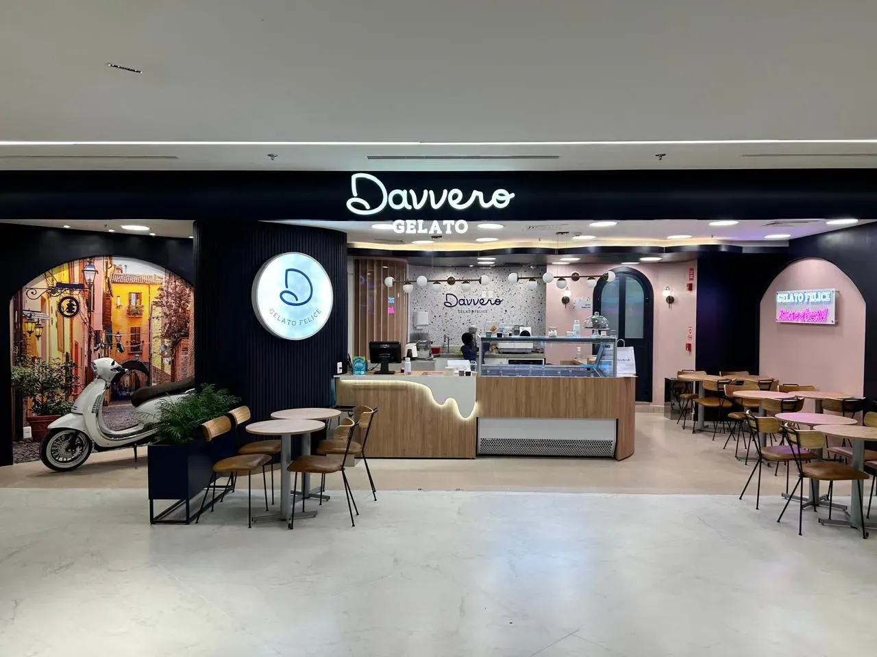 Interior de uma loja Davvero com balcão, mesas e decoração rosa e preta